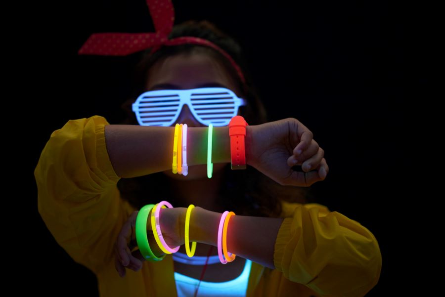 Vom Outfit bis zur Deko: Wie plane ich eine 90er Mottoparty? 2 Frau mit Neonarmbändern